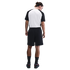 Rear view of a man wearing a black and white raglan T-shirt, black athletic shorts, and black sneakers, standing against a white background.