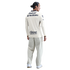 Back view of a man wearing a cream long-sleeved soccer jersey with sponsor logos and light gray wide-leg pants against a white background.