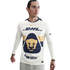 A man in a long-sleeved Pumas UNAM soccer jersey. The cream jersey features a large navy and gold feline head logo, with DHL, Nike, and Mifel branding.