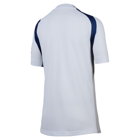 Rear view of a white short-sleeved athletic jersey featuring navy blue shoulder panels and gray side detailing.