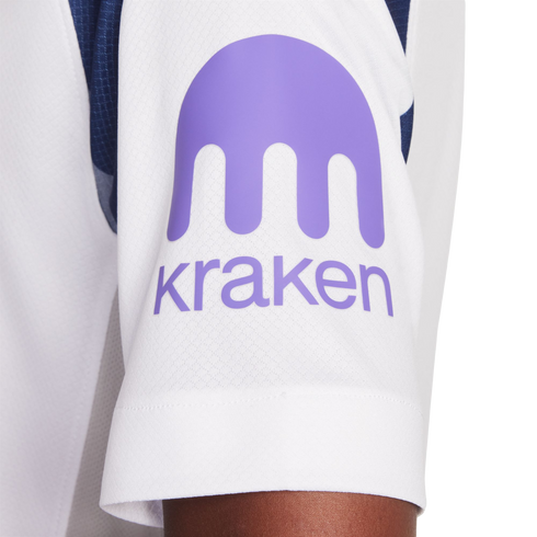Close-up of a white jersey sleeve featuring a purple logo consisting of an abstract kraken shape above the word "kraken" in lowercase.