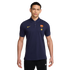 A man wearing a navy blue Nike FC Barcelona polo shirt with yellow branding and black Nike joggers, against a solid black background.