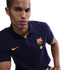 A man in a navy blue Nike FC Barcelona polo shirt featuring the club crest and yellow Spotify logo against a black background.