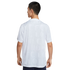 Rear view of a person wearing a white short-sleeved shirt with a subtle, all-over "CFC LONDON" typographic pattern.