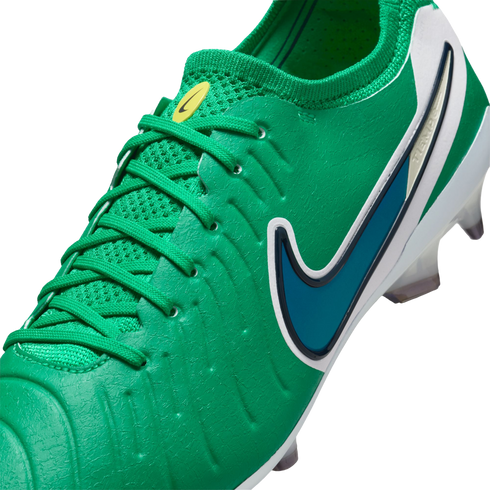 Close-up of a vibrant green Nike soccer cleat with a dark blue swoosh, white heel, and textured upper.