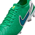 Close-up of a vibrant green Nike soccer cleat with a dark blue swoosh, white heel, and textured upper.