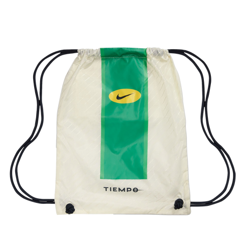 An off-white Nike Tiempo drawstring bag featuring a thick vertical green stripe, a yellow Nike swoosh logo, and black cords.