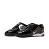 A pair of glossy black Nike Total 90 indoor soccer shoes with silver "90" branding, white swooshes, and yellow accents, shown against a white background.