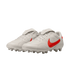 A pair of white Nike soccer cleats with bright red swoosh logos and fold-over tongues on a black background.