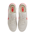 Top-down view of white Nike sneakers with bright red-orange accents and logos on a black background.