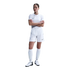 A woman in an all-white Nike soccer kit stands with her arms crossed against a plain white background.