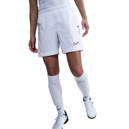 Lower half of a person wearing white Nike soccer shorts, knee-high socks, and cleats against a white background.
