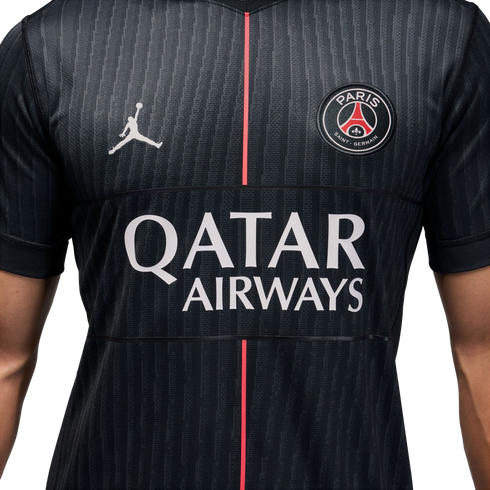 A black Jordan brand PSG soccer jersey with a white Jumpman logo, team crest, "QATAR AIRWAYS" logo, and a thin red vertical stripe down the center.