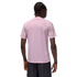 Rear view of a person with braided hair wearing a light pink pinstriped t-shirt and dark pinstriped shorts against a solid black background.