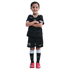 Young girl smiling with arms crossed, wearing a black Chelsea FC soccer kit and pink cleats against a solid black background.