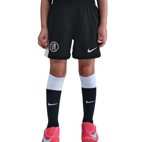 Person wearing black Chelsea FC soccer shorts, black and white Nike socks, and pink Nike soccer cleats against a black background.