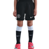 Person wearing black Chelsea FC soccer shorts, black and white Nike socks, and pink Nike soccer cleats against a black background.