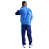 Rear view of a person wearing a two-tone blue Nike tracksuit and matching sneakers against a black background.