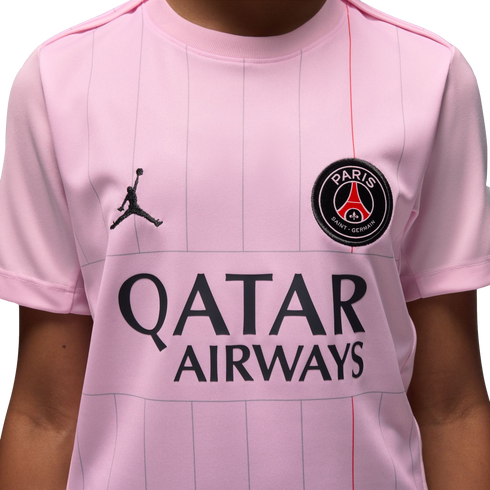 Close-up of a pink Paris Saint-Germain jersey with the Jordan Jumpman logo, the PSG club crest, and the Qatar Airways sponsor logo.