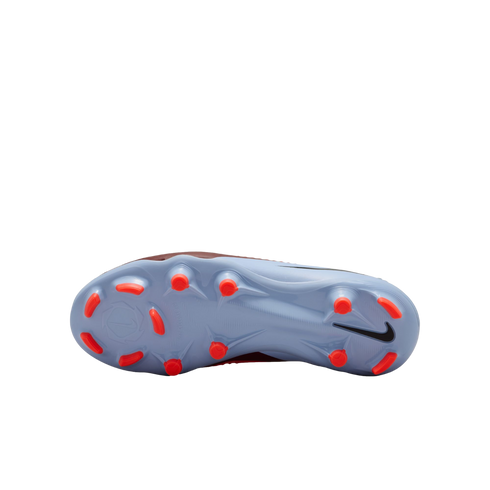 Underside view of a light blue Nike soccer cleat with bright orange studs and a black Nike swoosh, set against a solid black background.
