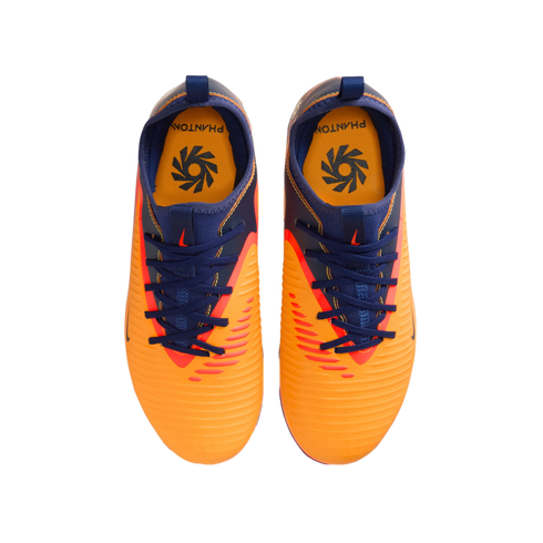 Top-down view of a pair of bright orange and navy blue Nike Phantom soccer cleats on a black background.