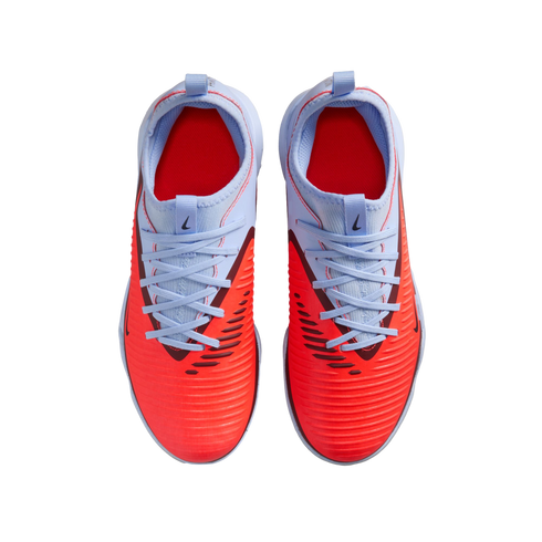 Top-down view of Nike soccer shoes with a textured bright red forefoot and light blue heel and laces, set against a black background.