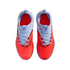 Top-down view of Nike soccer shoes with a textured bright red forefoot and light blue heel and laces, set against a black background.
