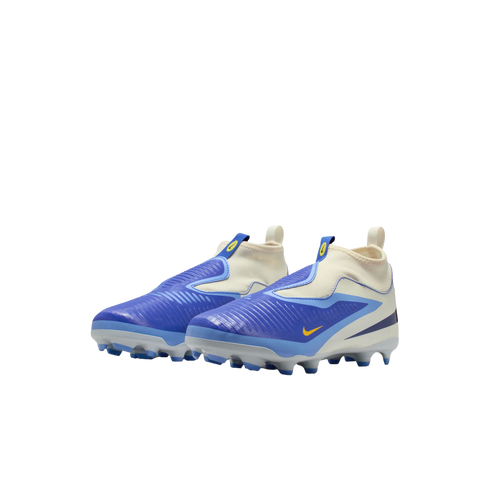 A pair of blue and white Nike kids' laceless soccer cleats with yellow accents, set against a black background.