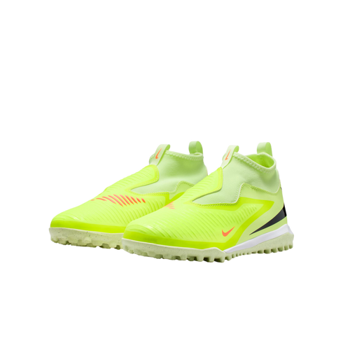 A pair of neon yellow, laceless Nike soccer turf shoes with orange and black swoosh accents on a solid black background.