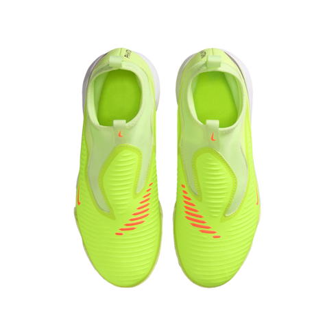A top-down view of neon yellow Nike soccer cleats with orange accents and a slip-on design, set against a solid black background.