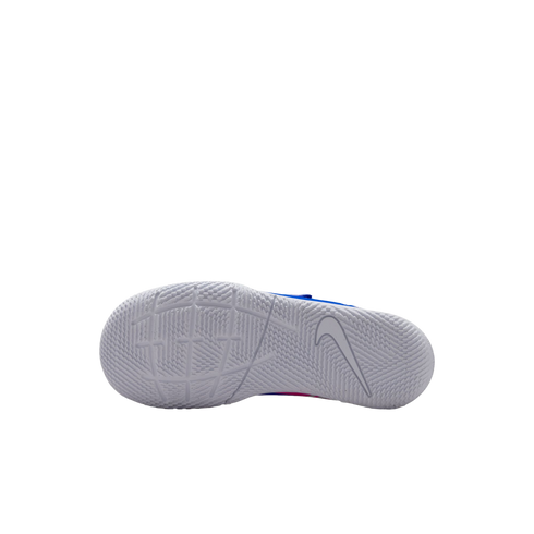 The white outsole of a Nike shoe with a detailed traction pattern and a Swoosh logo is shown against a solid black background, with bits of blue and pink visible on the upper.