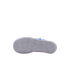 The white outsole of a Nike shoe with a detailed traction pattern and a Swoosh logo is shown against a solid black background, with bits of blue and pink visible on the upper.