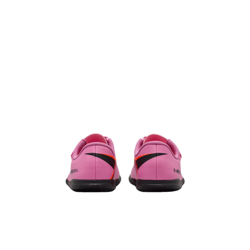 Rear view of a pair of pink Nike Mercurial soccer shoes with black and orange graphics, set against a solid black background.