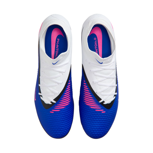 Overhead view of a pair of white and blue Nike Phantom soccer cleats with pink accents and white laces against a black background.