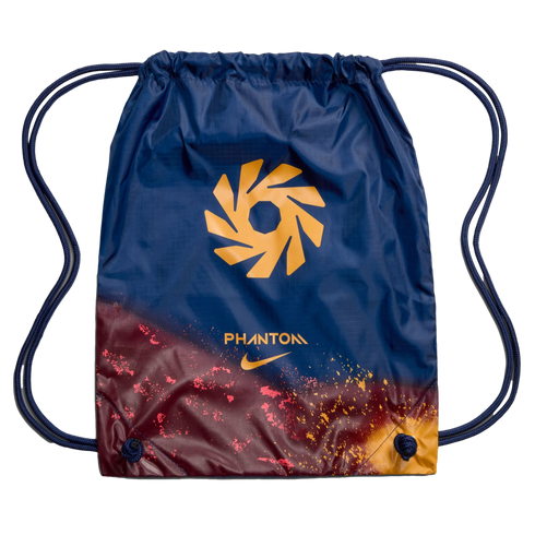 A navy blue Nike Phantom drawstring bag with a gold geometric logo and a maroon and orange speckled gradient design at the bottom.
