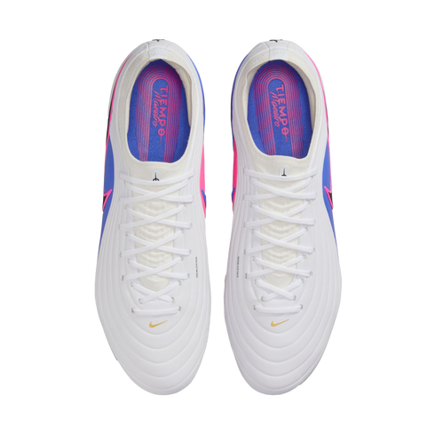 Top-down view of a pair of white soccer cleats with white laces and pink and blue accents. The colorful insoles feature "TIEMPO Maestro" text.