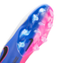 Close-up bottom view of a Nike soccer cleat featuring a vibrant blue and pink gradient soleplate with clear studs and a small black swoosh.