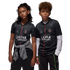 A young girl and boy wear matching black Paris Saint-Germain soccer jerseys with red vertical stripes and logos while posing against a solid black background.