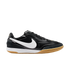 Profile of a black Nike Tiempo indoor soccer shoe with a white swoosh, white midsole, and gum rubber outsole, displayed against a black background.