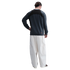 Rear view of a person wearing a dark grey panelled sweatshirt and cream wide-leg cargo pants against a black background.
