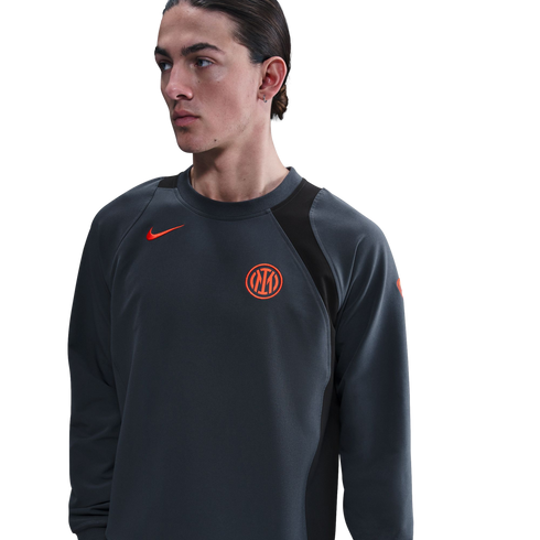 Person wearing a charcoal gray Nike sweatshirt with an orange Inter Milan crest and swoosh, against a black background.