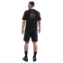Rear view of a man wearing a black Nike Inter Milan T-shirt with orange graphics, black cargo shorts, and black sneakers on a plain black background.