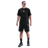 Man standing in a black Nike Inter Milan t-shirt with orange logos, black cargo shorts, and black sneakers against a solid black background.