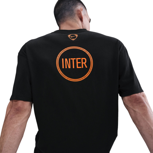 Back view of a man wearing a black Nike t-shirt with a large orange "INTER" graphic inside a circle and a small orange Nike logo at the neckline.