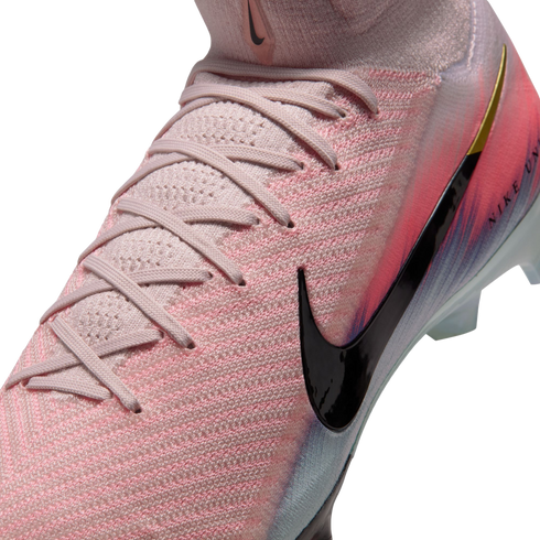 Close-up of a pink Nike soccer cleat with a textured Flyknit upper, pink laces, a large black swoosh, and a vibrant color gradient.