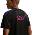 Rear view of a man wearing a black athletic shirt featuring a pink and blue gradient script logo and colorful shoulder stripes.