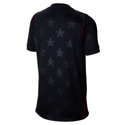 Back view of a black short-sleeved jersey with a subtle tonal star pattern and thin red piping along the seams, set against a black background.