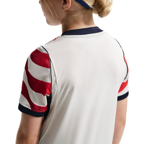 Rear view of a person wearing a white athletic jersey with red and white striped sleeves and navy blue trim.