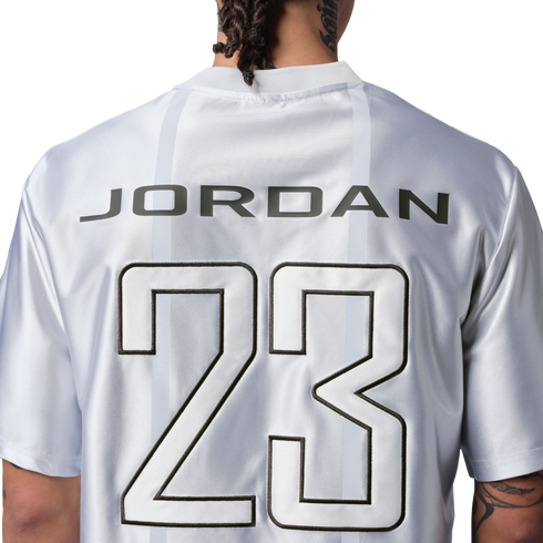 Back of a white jersey with "JORDAN" and a large number "23" printed in black and white.