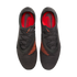 Top-down view of black and grey Nike Phantom soccer cleats featuring orange accents and insoles, set against a black background.